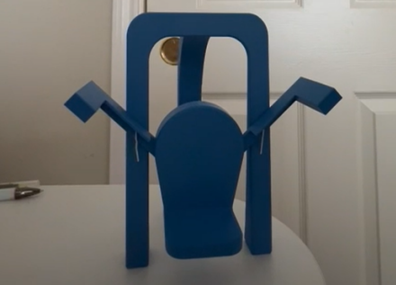 The first conceptual prototype: a small blue 3D-printed model of the chest-supported frame with angled input arms