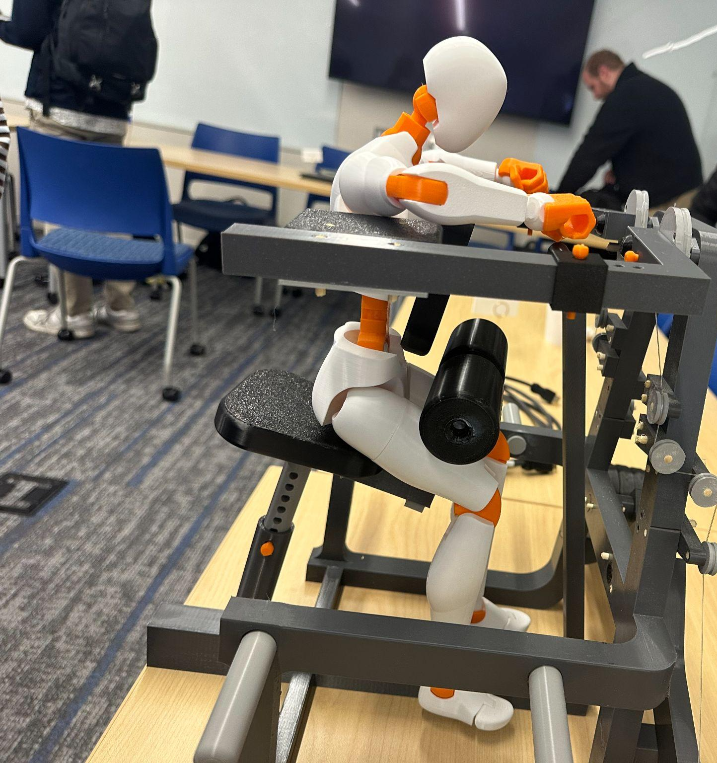 Final 3D-printed rendition of the lat adduction machine, side view, with an articulated test figure seated in position