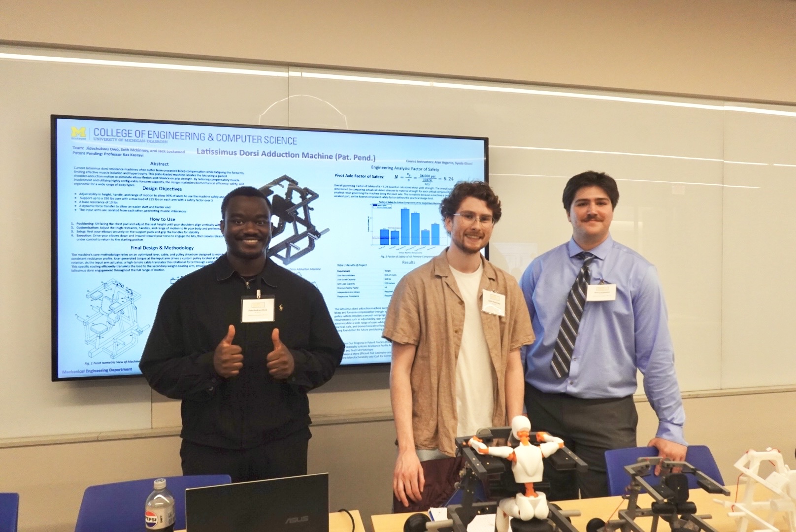 Jidechukwu Owo, Seth McKinney, and Jack Lockwood standing behind their prototypes at the senior design showcase
